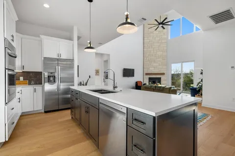 a kitchen with white cabinets and stainless steel appliances