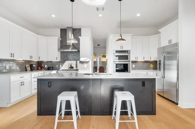 a kitchen with white cabinets and refrigerator