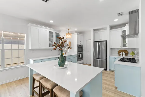 a large kitchen with a lot of counter space and wooden floor