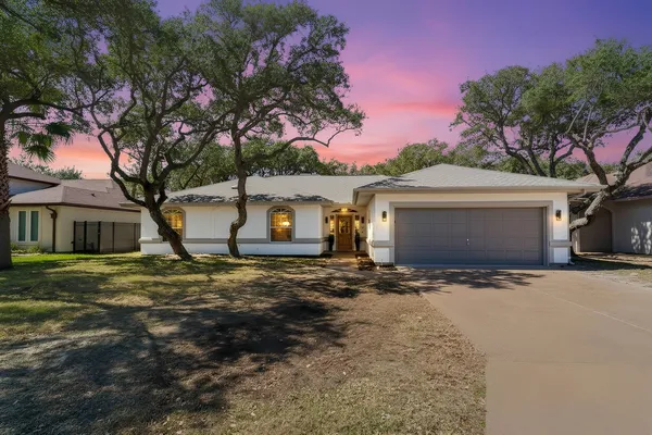 a view of a house with a yard and tree