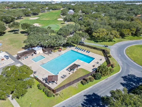 an aerial view of residential houses with outdoor space and trees