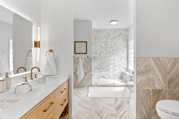 a bathroom with a double vanity sink toilet and shower