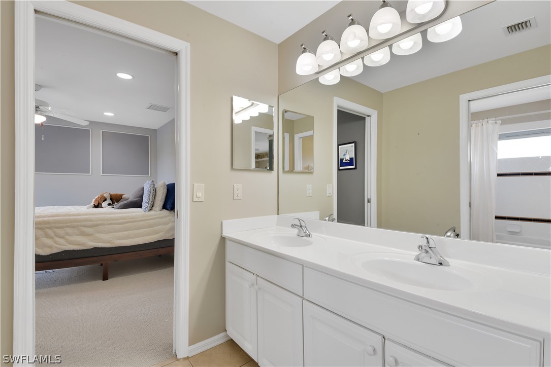 12834 Timber Ridge Drive Fort Myers, FL 33913 - Photo 20 of 31 a bathroom with a double vanity sink and a mirror with bathtub
