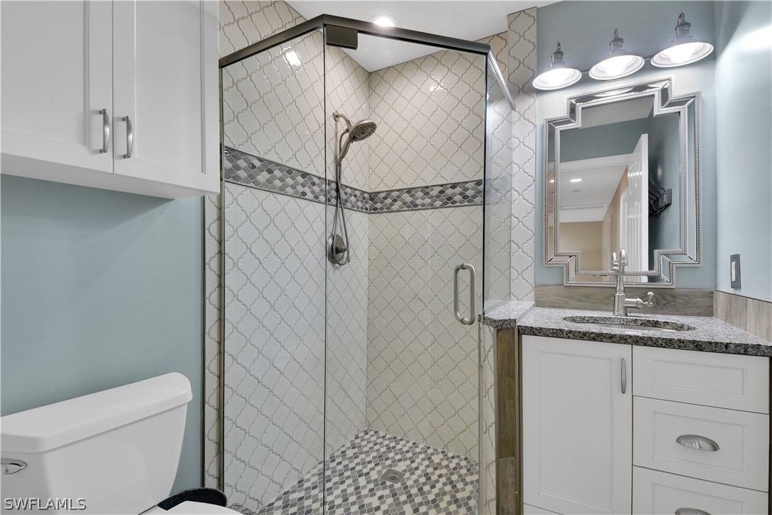12834 Timber Ridge Drive Fort Myers, FL 33913 - Photo 25 of 31 a bathroom with a granite countertop sink a mirror and a shower