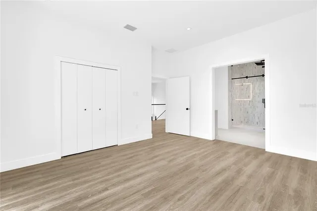 a view of an empty room with wooden floor