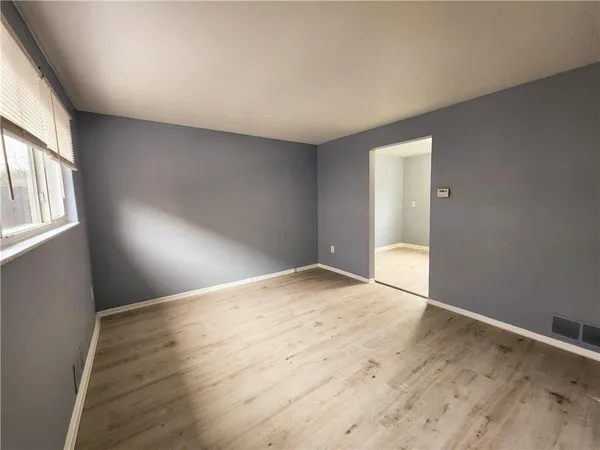 a view of empty room with wooden floor