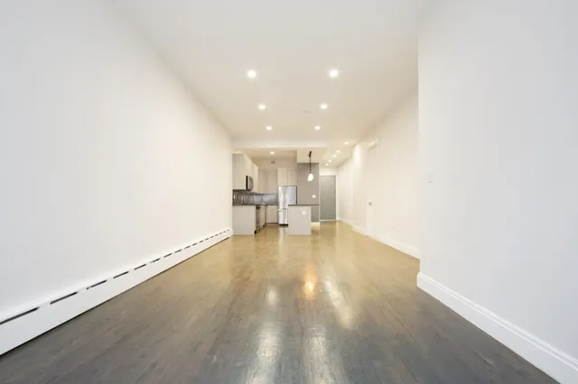 a view of empty room with wooden floor
