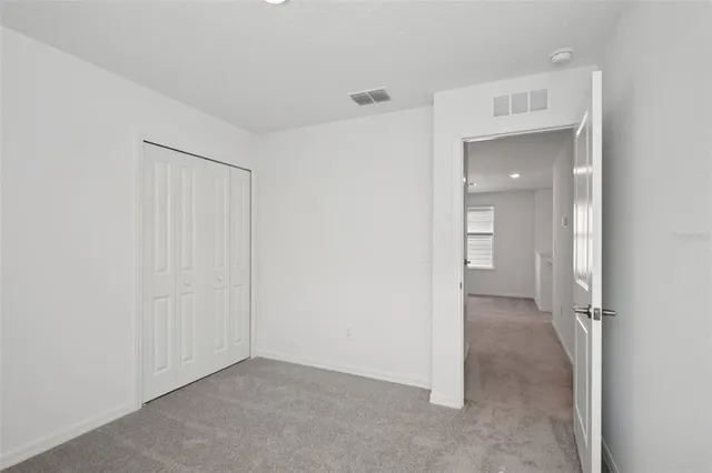 a view of a room with a hallway and closet