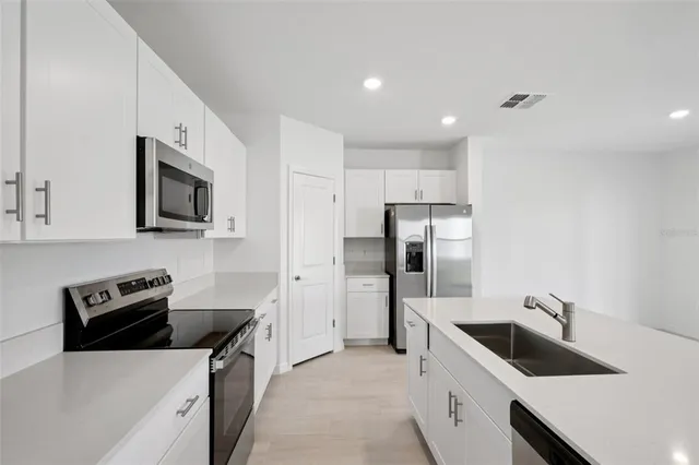 a kitchen with a refrigerator stove and sink