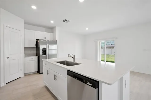 a kitchen with stainless steel appliances granite countertop a sink a stove and a refrigerator