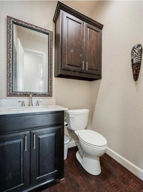 5001 Meridian Lane, Unit 2103 Addison, TX 75001 - Photo 22 of 26 Bathroom featuring dark wood-finish flooring, a white toilet, and a vanity with a white countertop and dark cabinetry