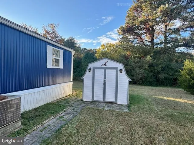 a view of a barn in the yard with large trees