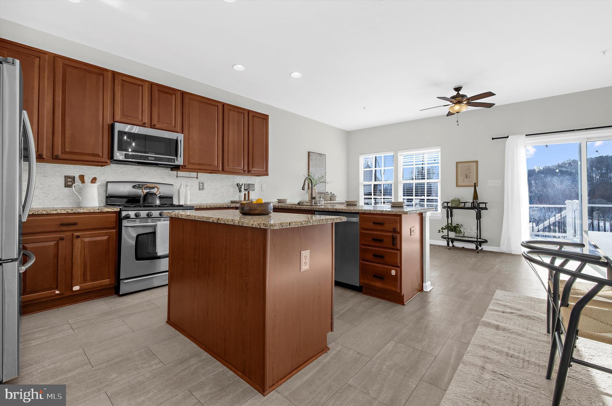 3115 Raking Leaf Drive Abingdon, MD 21009 - Photo 12 of 61 a kitchen with stainless steel appliances granite countertop a stove top oven a sink dishwasher a dining table and chairs with wooden floor
