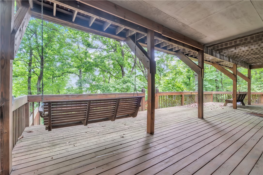 149 Inlet Pointe Drive Anderson, SC 29625 - Photo 30 of 43 A spacious wooden deck with a swing overlooks a lush, verdant treeline.