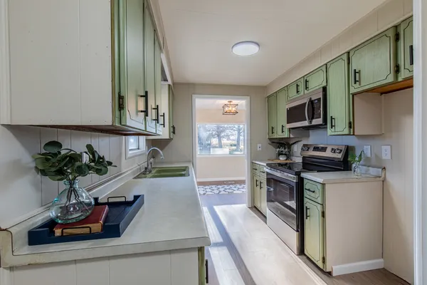 a kitchen with stainless steel appliances granite countertop a refrigerator a stove a sink and a microwave