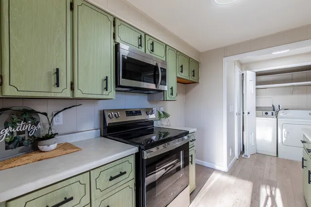 a kitchen with stainless steel appliances granite countertop a stove a microwave and cabinets