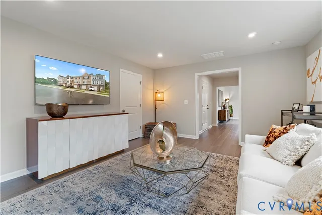a living room with furniture and a wooden floor