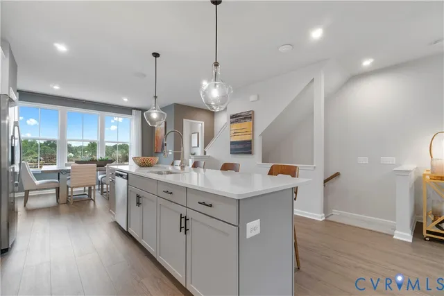 a kitchen with counter top space sink stove and wooden floor