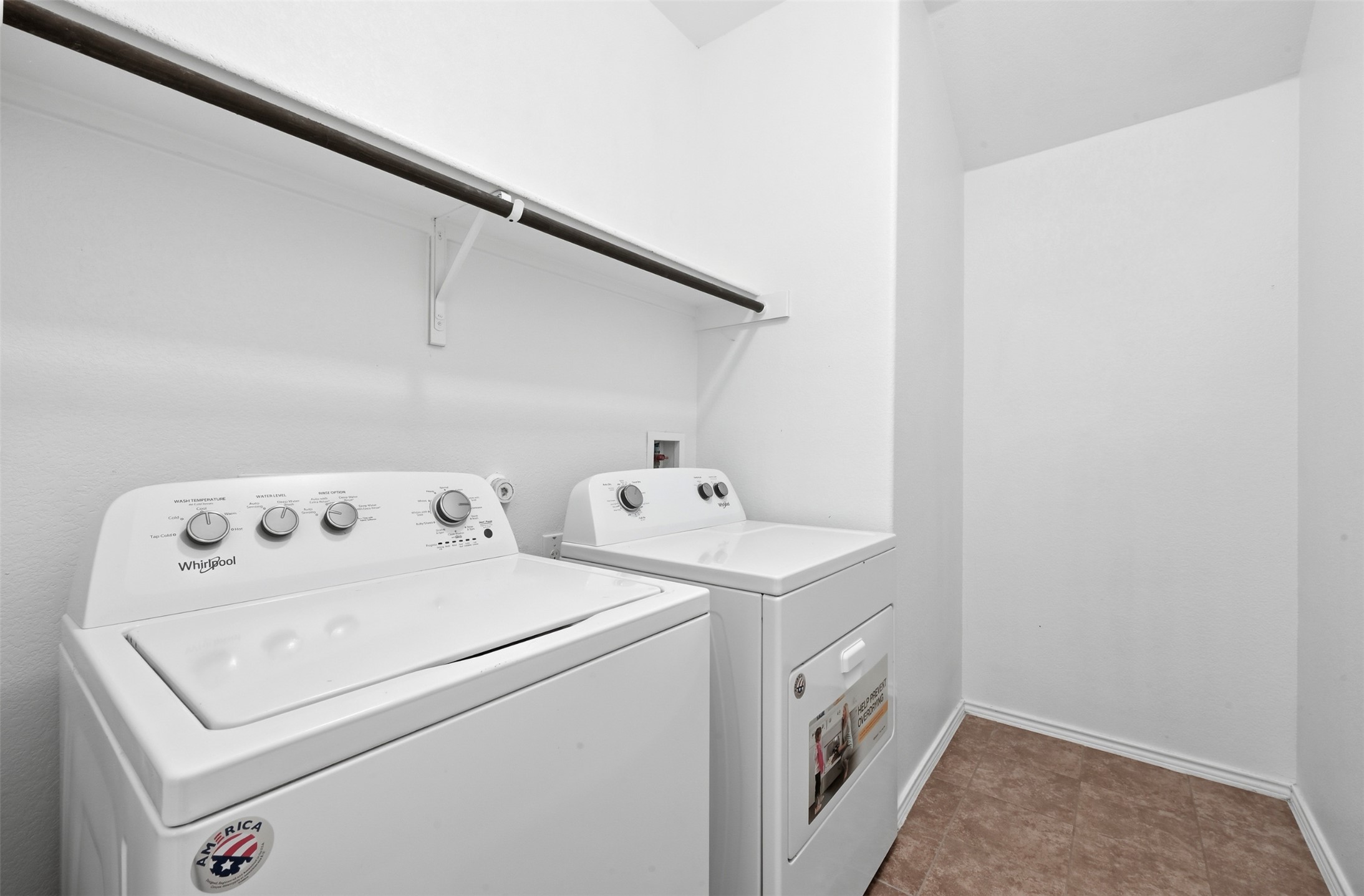 303 Limerick Road Buda, TX 78610 - Photo 18 of 23 Dedicated laundry area featuring a hanging rod, white walls, and brown-toned tile flooring