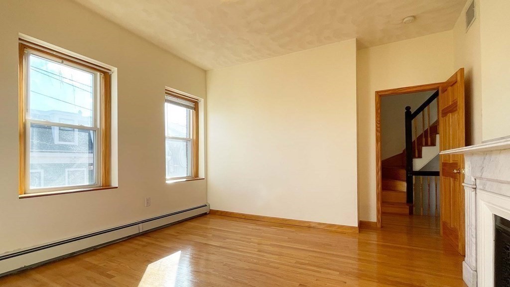 21 Parker Street Boston, MA 02129 - Photo 12 of 28 a view of an empty room with wooden floor and a window