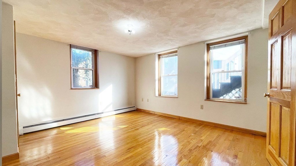 21 Parker Street Boston, MA 02129 - Photo 15 of 28 a view of an empty room with wooden floor and a window