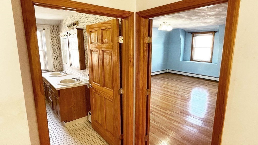 21 Parker Street Boston, MA 02129 - Photo 17 of 28 a view of a hallway with wooden floor and staircase