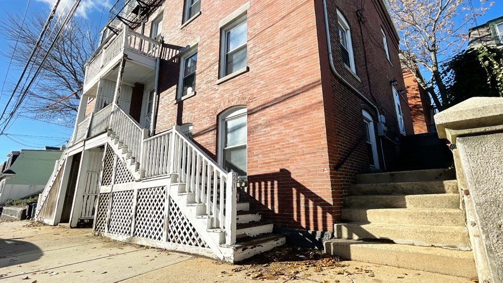21 Parker Street Boston, MA 02129 - Photo 2 of 28 a view of a house with a wooden fence