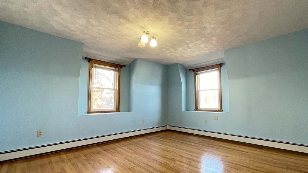 21 Parker Street Boston, MA 02129 - Photo 21 of 28 an empty room with wooden floor and windows