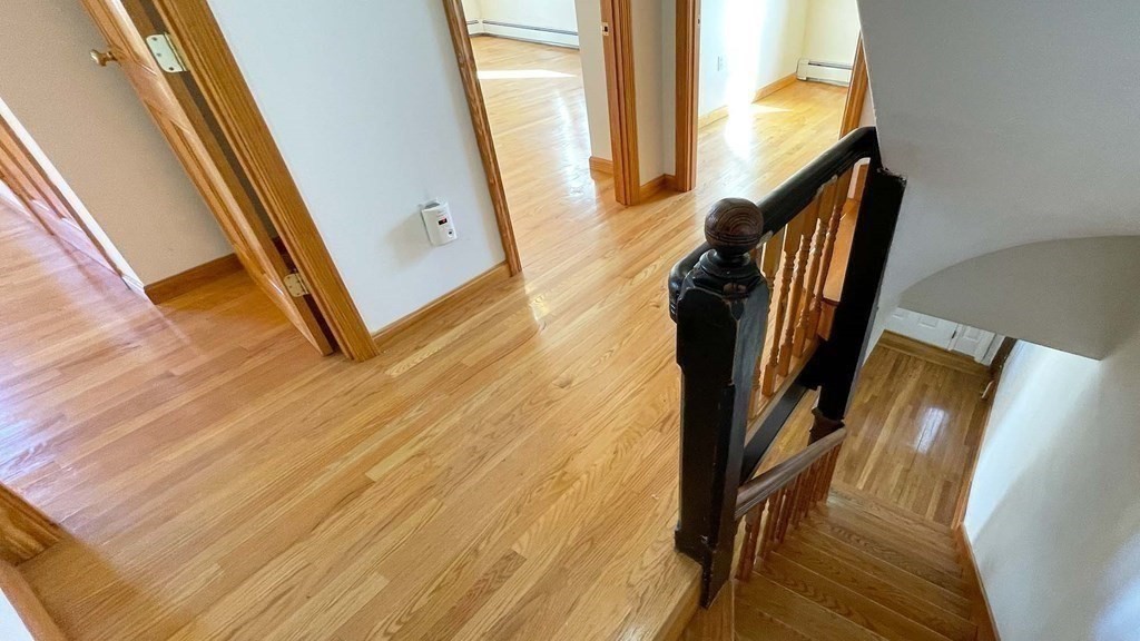 21 Parker Street Boston, MA 02129 - Photo 10 of 28 a view of a hallway with wooden floor and stairs