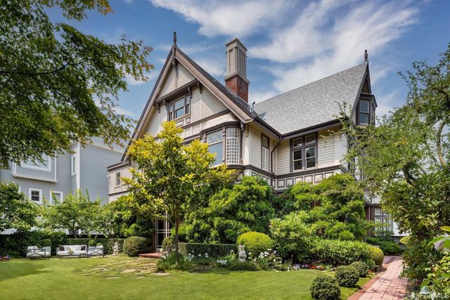 a front view of a house with a yard and potted plants