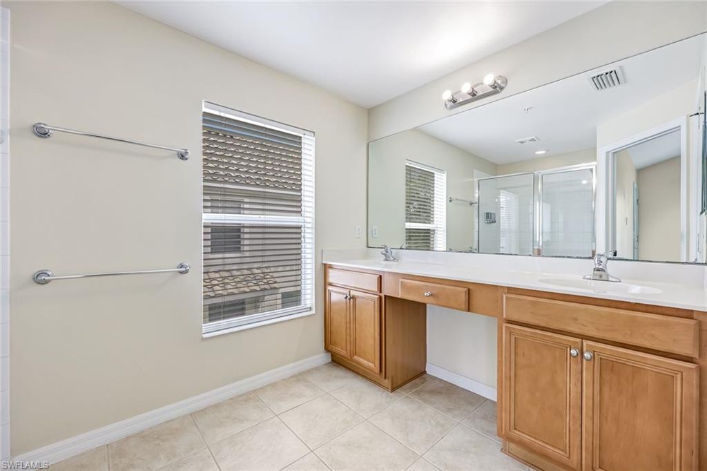 16162 Ravina Way, Unit 65 Naples, FL 34110 - Photo 15 of 22 a large bathroom with a sink and a large mirror