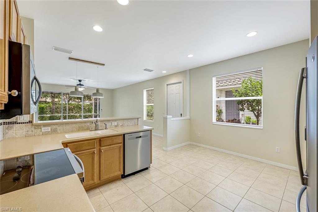 16162 Ravina Way, Unit 65 Naples, FL 34110 - Photo 7 of 22 a large white kitchen with a large window