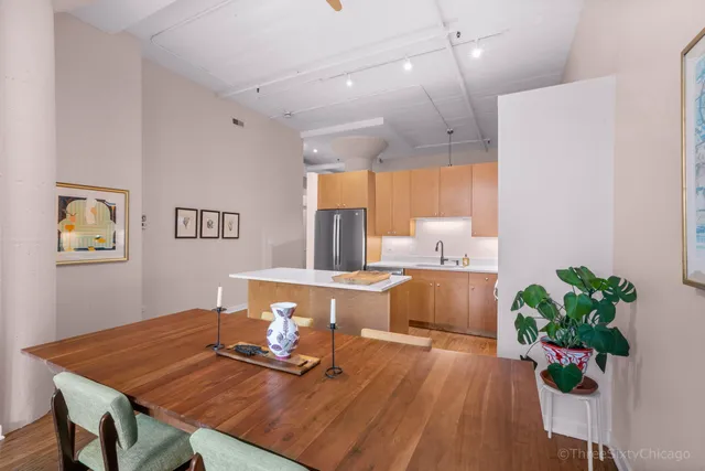 a kitchen with stainless steel appliances a sink a stove a refrigerator cabinets and a window