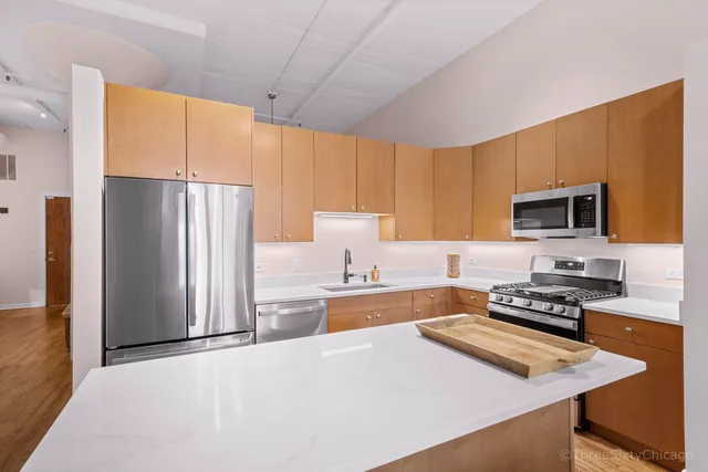 a large kitchen with stainless steel appliances granite countertop a refrigerator stove and oven