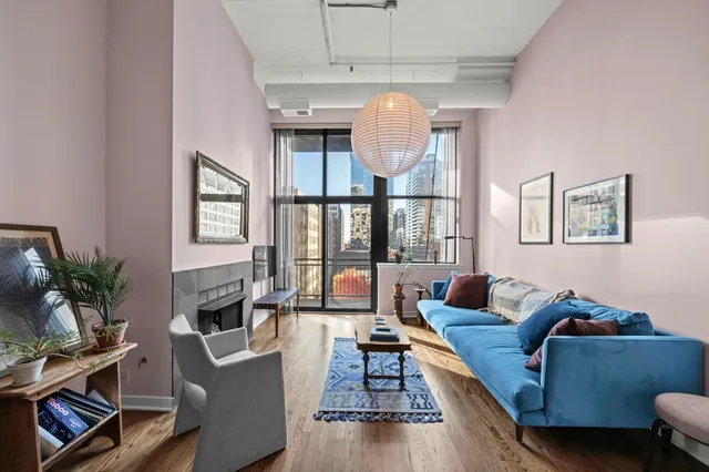 a living room with furniture kitchen view and a wooden floor