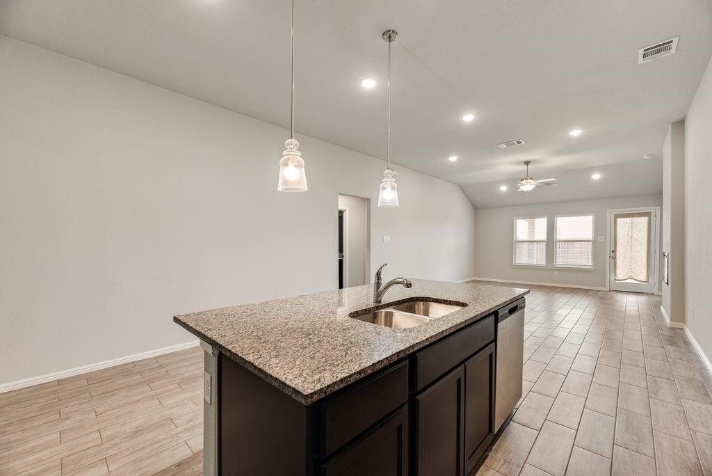 14216 Aberavon Drive Pilot Point, TX 76258 - Photo 8 of 19 Kitchen island with granite countertop and double stainless steel sink
