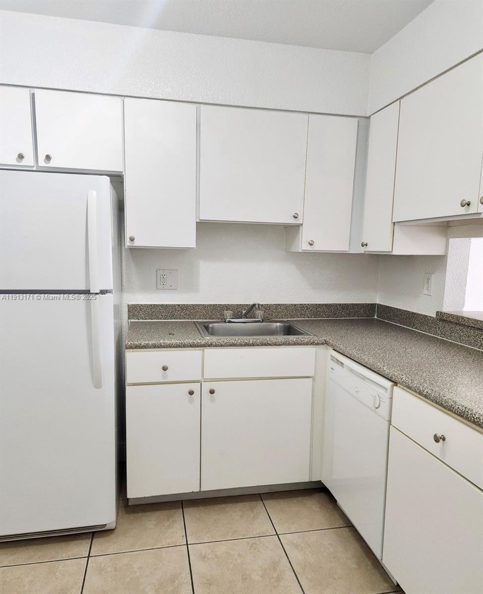 5201 Geneva Court, Unit 307 Doral, FL 33166 - Photo 3 of 19 a kitchen with granite countertop cabinets and refrigerator