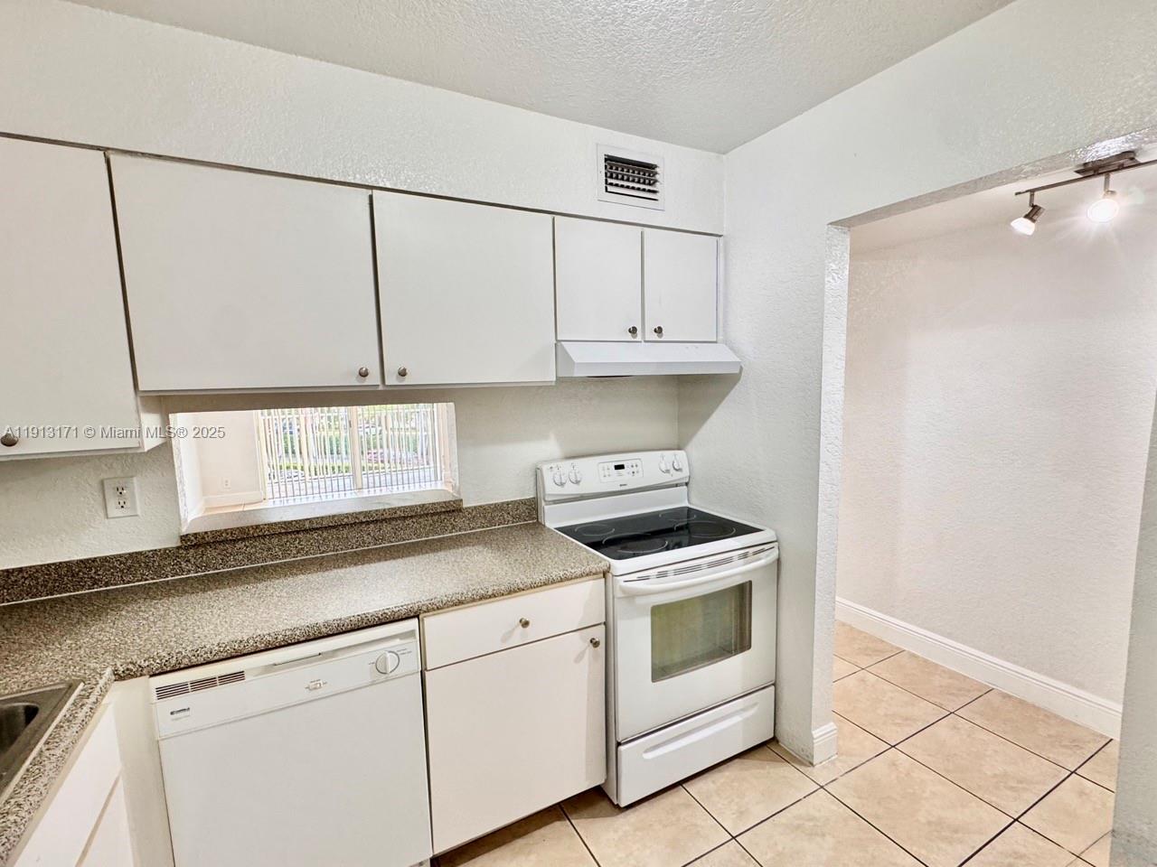 5201 Geneva Court, Unit 307 Doral, FL 33166 - Photo 4 of 19 a kitchen with white cabinets and white appliances