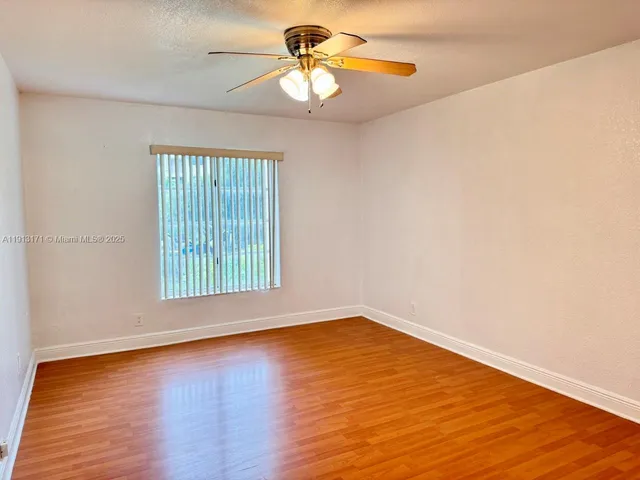 a view of a room with wooden floor and a window