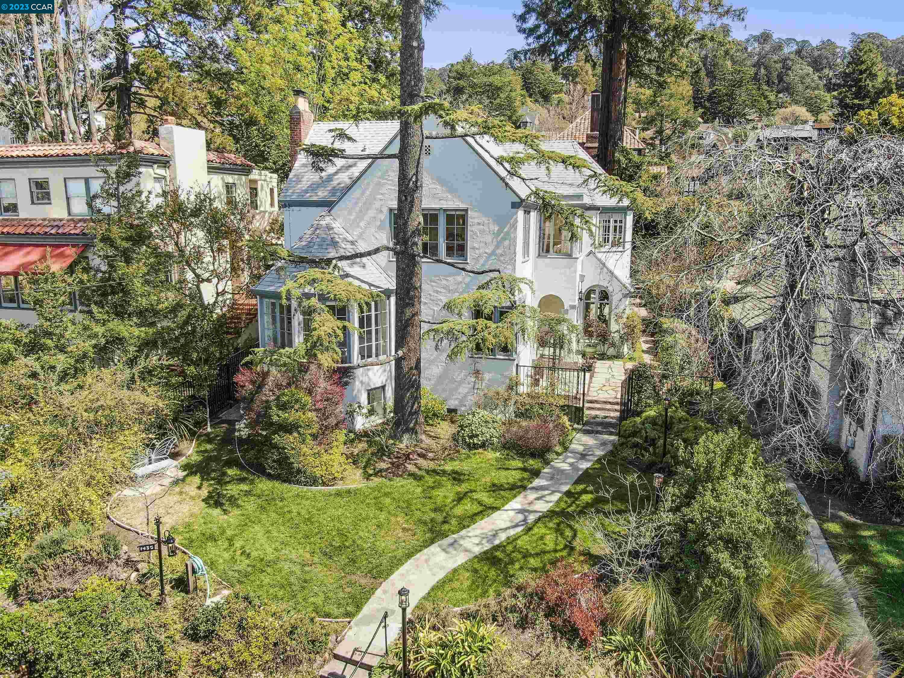 a view of a white house with a big yard and potted plants
