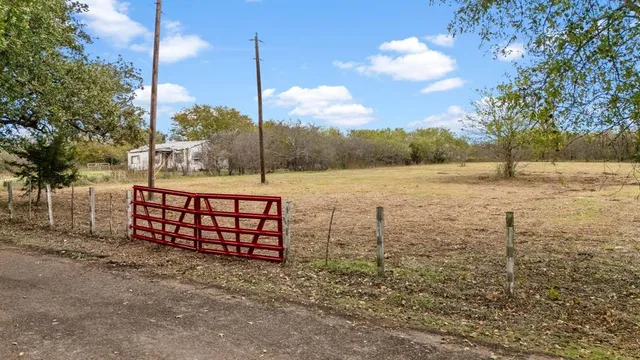 a view of a yard with wooden fence