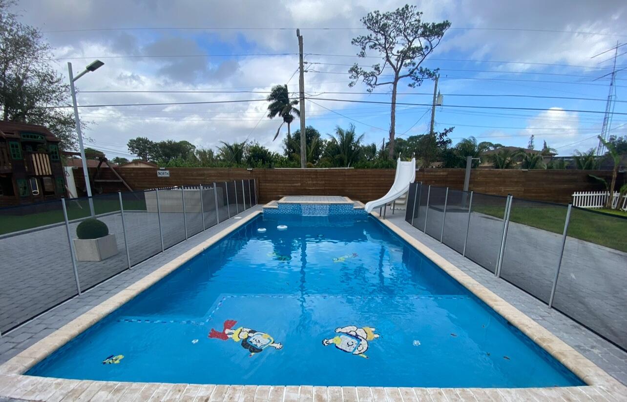 15276 Harrison Road Delray Beach, FL 33484 - Photo 2 of 75 a view of a swimming pool with a patio