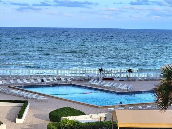 a view of a swimming pool with lawn chairs