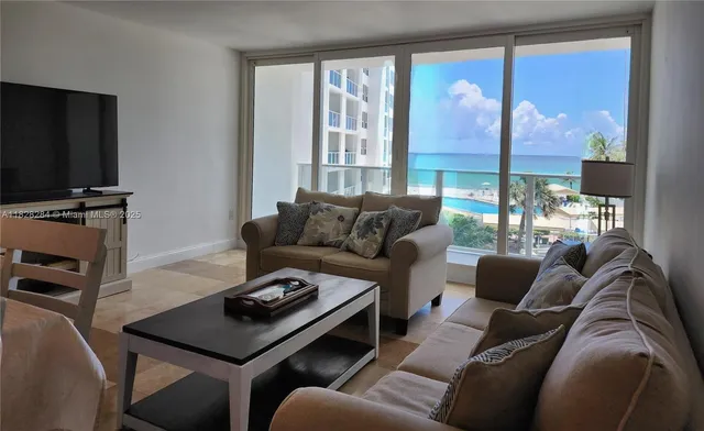 a living room with furniture a large window and a flat screen tv