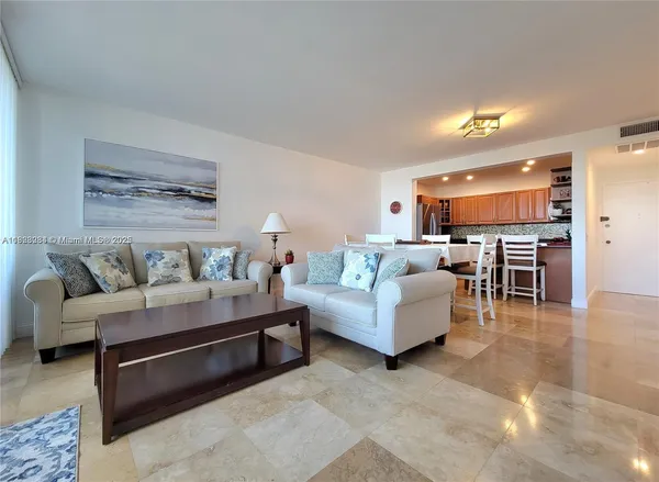 a living room with furniture and kitchen view