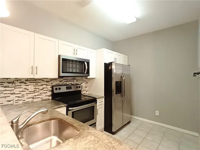 a kitchen with stainless steel appliances granite countertop a refrigerator and a stove top oven