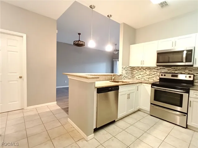 a kitchen with granite countertop a stove top oven and cabinets
