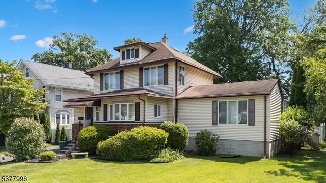 a front view of a house with yard and green space
