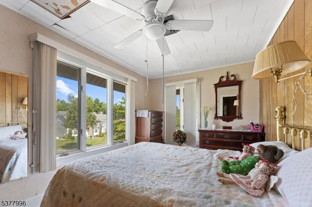 a bedroom with a bed potted plant and a large window
