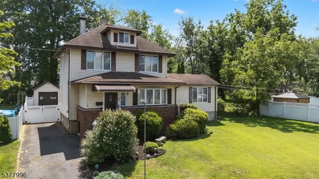 a front view of a house with a yard and potted plants